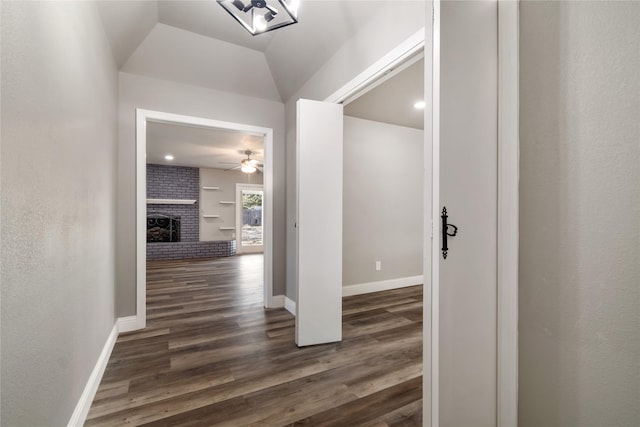 corridor featuring lofted ceiling and dark wood-type flooring