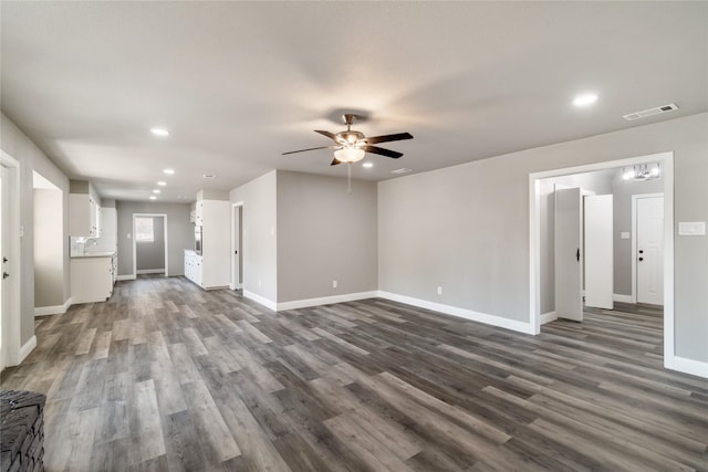 unfurnished living room featuring ceiling fan and dark wood-type flooring