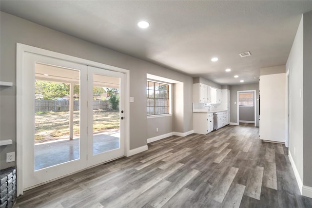 unfurnished living room featuring wood-type flooring and a wealth of natural light