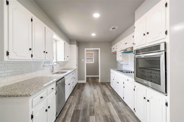 kitchen with light stone counters, sink, white cabinetry, and stainless steel appliances