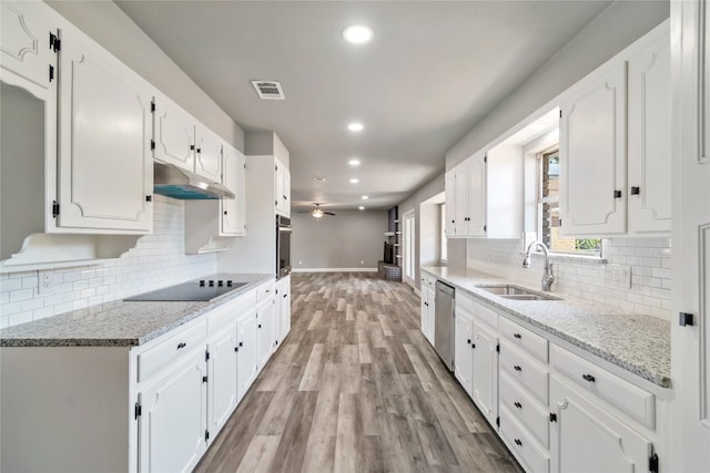 kitchen with ceiling fan, white cabinets, light stone counters, and light wood-type flooring