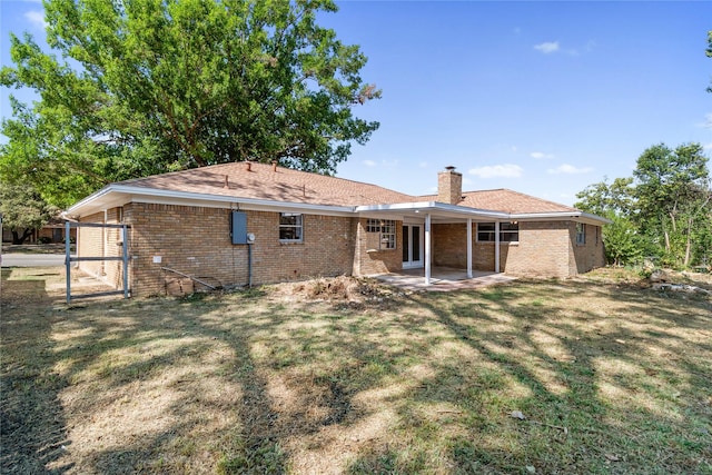 rear view of property with a lawn and a patio area