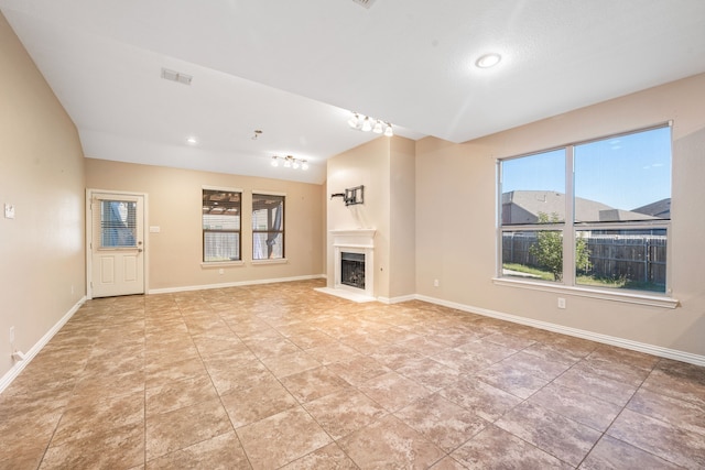 unfurnished living room featuring lofted ceiling and tile patterned floors