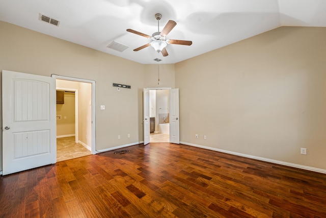 unfurnished bedroom with vaulted ceiling, connected bathroom, hardwood / wood-style floors, and ceiling fan