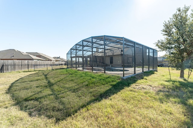 view of yard featuring a fenced in pool and glass enclosure