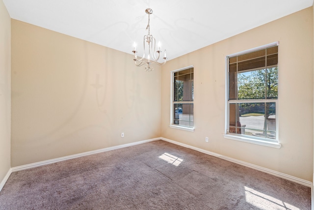 carpeted spare room with a chandelier