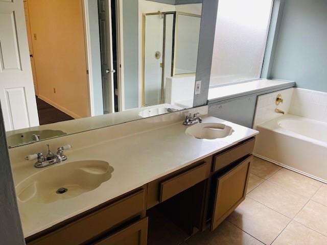 full bath with double vanity, a garden tub, tile patterned flooring, and a sink