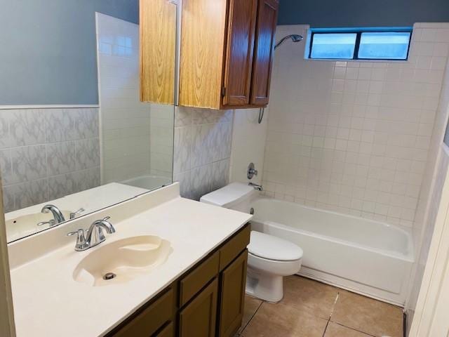 full bath with bathtub / shower combination, tile patterned flooring, toilet, vanity, and tile walls