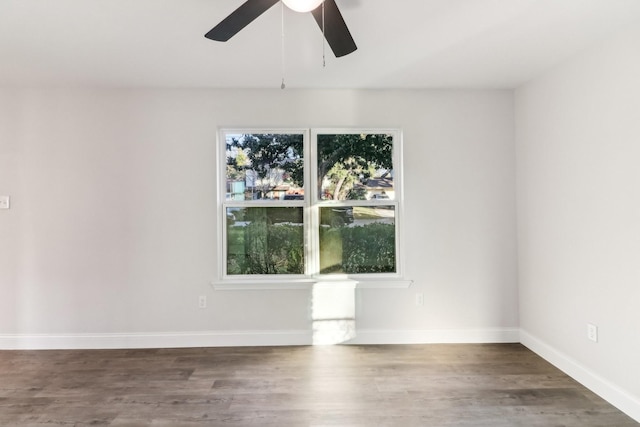 spare room with a wealth of natural light, dark hardwood / wood-style floors, and ceiling fan