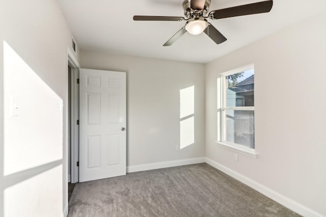 carpeted spare room with ceiling fan