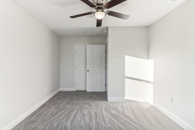 unfurnished bedroom featuring ceiling fan, a closet, and light colored carpet