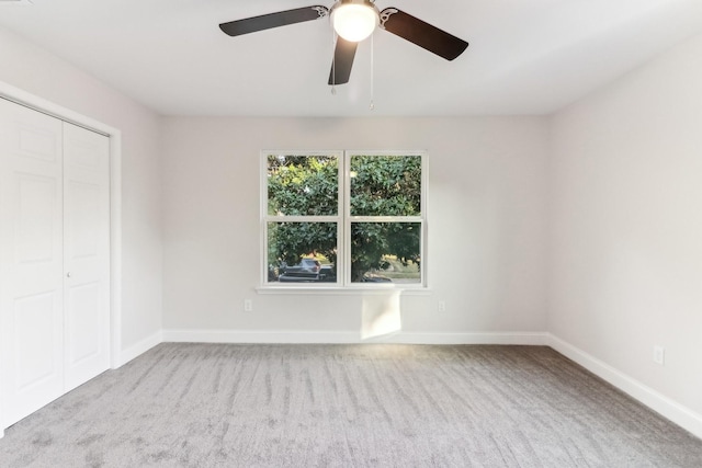 unfurnished bedroom featuring a closet, light colored carpet, and ceiling fan