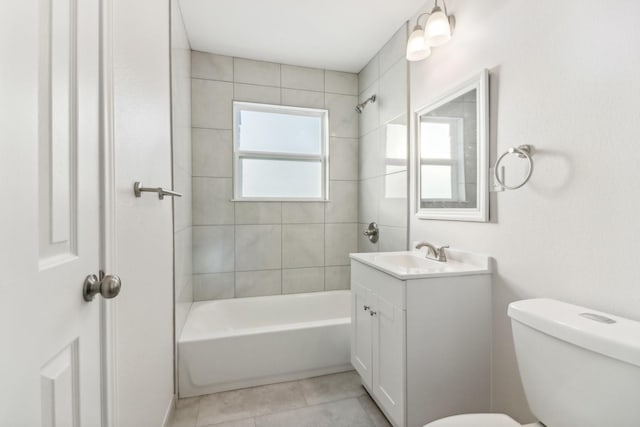 full bathroom featuring tiled shower / bath, vanity, toilet, and tile patterned floors