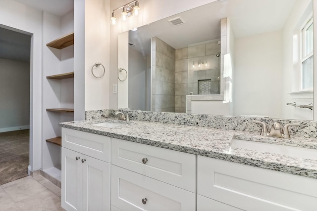 bathroom with tile patterned flooring, built in shelves, a shower, and vanity