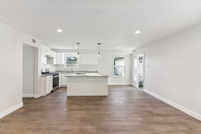 kitchen with sink, hanging light fixtures, a center island, gas stove, and white cabinets