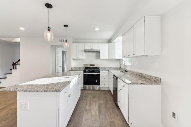 kitchen featuring white cabinetry, a center island, stainless steel appliances, and hardwood / wood-style flooring