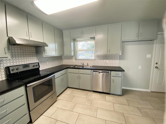 kitchen featuring gray cabinetry, sink, backsplash, light tile patterned flooring, and appliances with stainless steel finishes