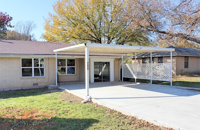 back of house featuring a carport and a lawn