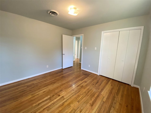 unfurnished bedroom featuring wood-type flooring and a closet