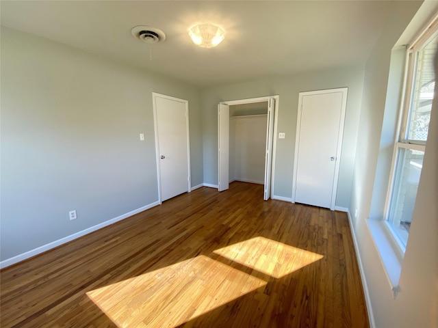 unfurnished bedroom with dark hardwood / wood-style flooring