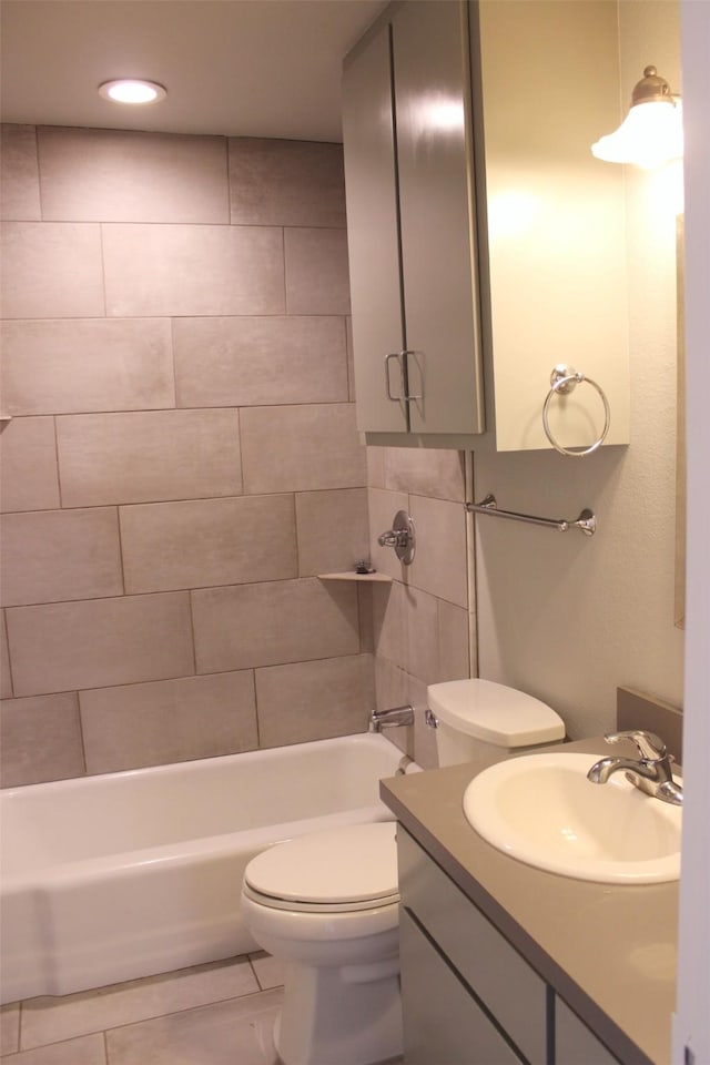 full bathroom featuring tile patterned flooring, vanity, toilet, and tiled shower / bath