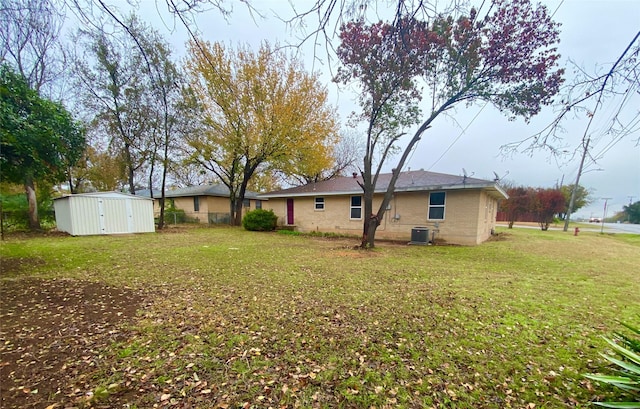 view of yard featuring a storage unit and central AC