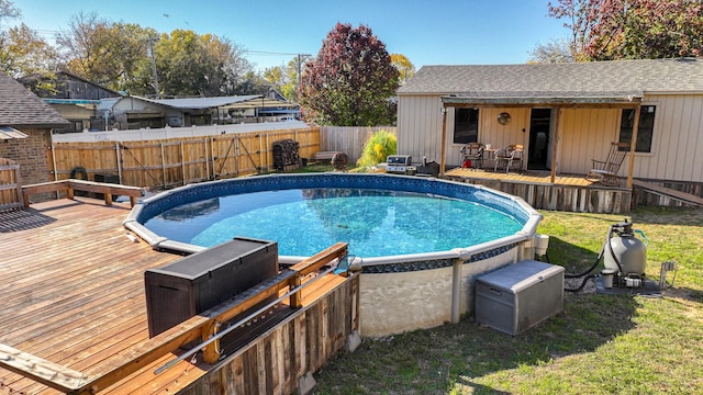 view of pool with a wooden deck and a lawn