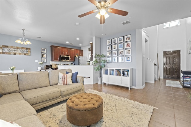 tiled living room featuring ceiling fan with notable chandelier