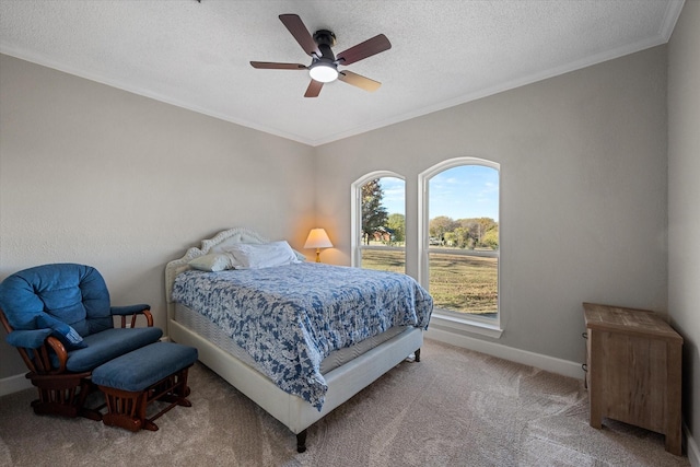 bedroom featuring ceiling fan, ornamental molding, a textured ceiling, and carpet flooring