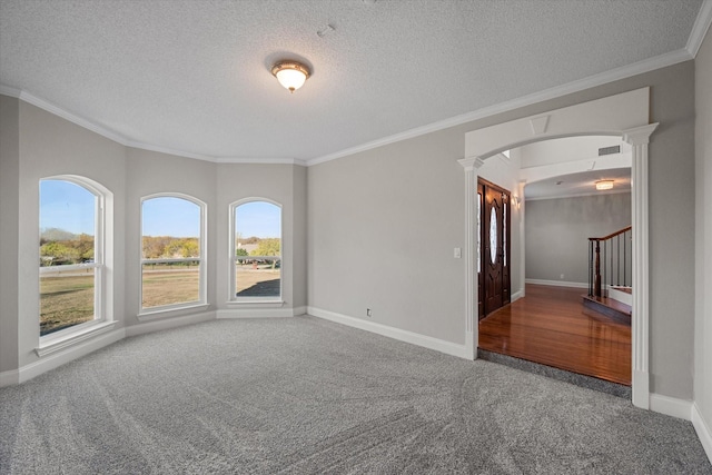 empty room with ornamental molding, carpet flooring, and a textured ceiling