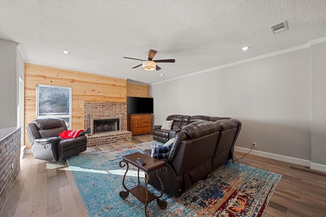 living room with crown molding, wooden walls, and wood-type flooring