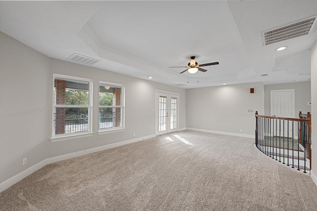 unfurnished room featuring carpet flooring, a raised ceiling, ceiling fan, and french doors