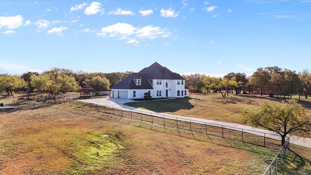 rear view of house featuring an outbuilding, a rural view, and a lawn