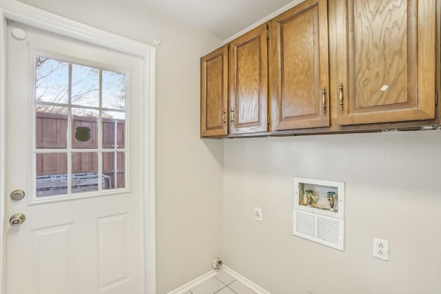 laundry room featuring electric dryer hookup, hookup for a washing machine, light tile patterned floors, and cabinets