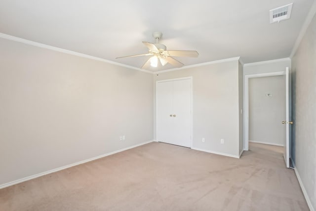 unfurnished bedroom with ceiling fan, crown molding, and light colored carpet