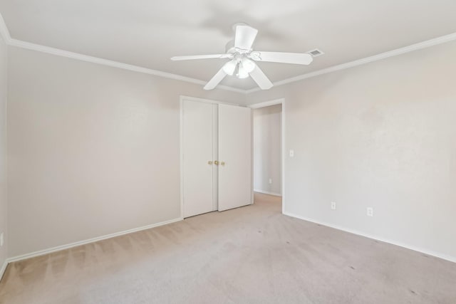 spare room with light carpet, ceiling fan, and ornamental molding