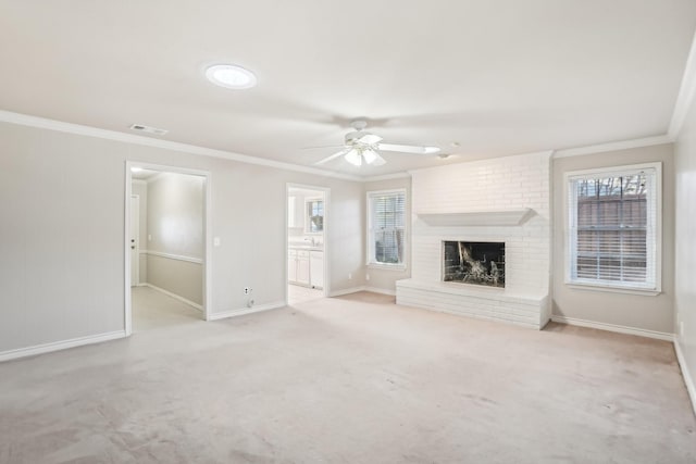 unfurnished living room featuring light carpet, a fireplace, crown molding, and ceiling fan