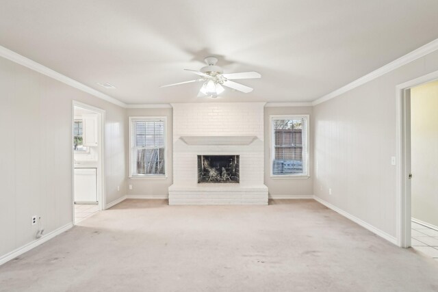 unfurnished living room featuring ornamental molding, light colored carpet, a brick fireplace, and a healthy amount of sunlight