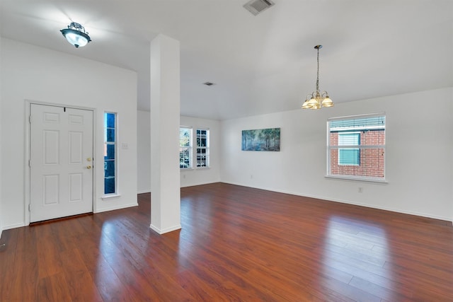 entryway with plenty of natural light, dark hardwood / wood-style flooring, and an inviting chandelier