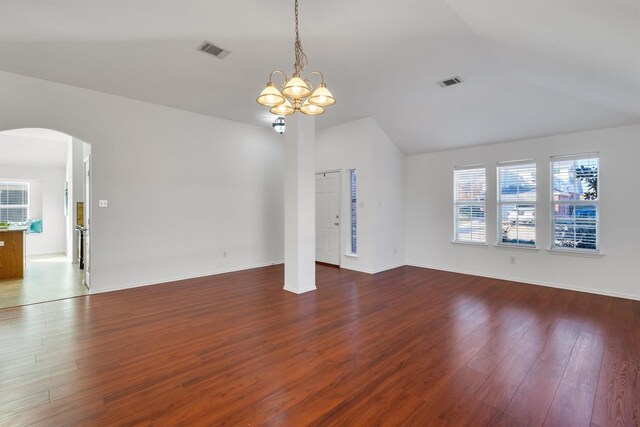 unfurnished living room with vaulted ceiling, dark hardwood / wood-style flooring, and an inviting chandelier