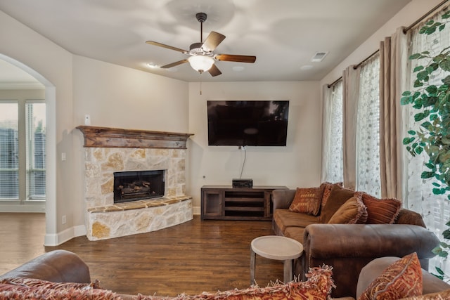 living room featuring a fireplace, dark hardwood / wood-style flooring, plenty of natural light, and ceiling fan