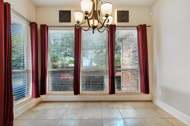 unfurnished dining area featuring a wealth of natural light, light tile patterned floors, and a notable chandelier