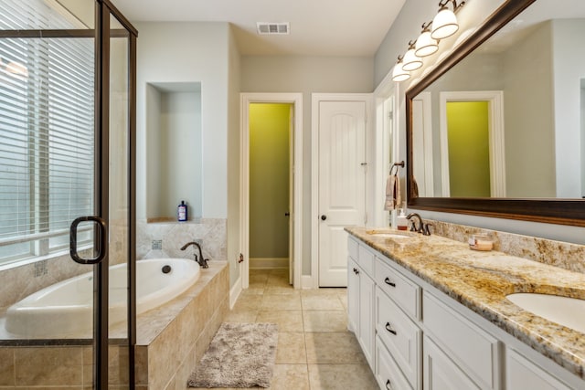 bathroom featuring vanity, tile patterned floors, and tiled tub