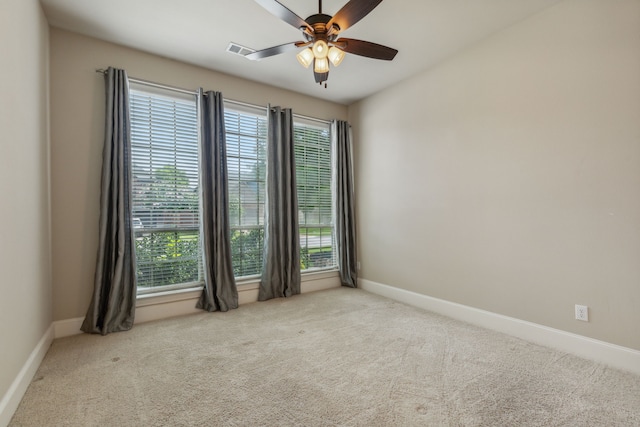 empty room featuring ceiling fan and light colored carpet