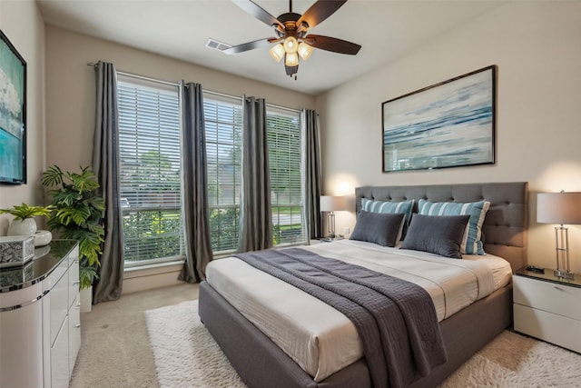 carpeted bedroom with ceiling fan and multiple windows