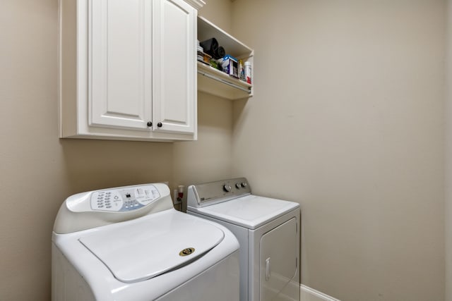 laundry area featuring cabinets and washer and clothes dryer