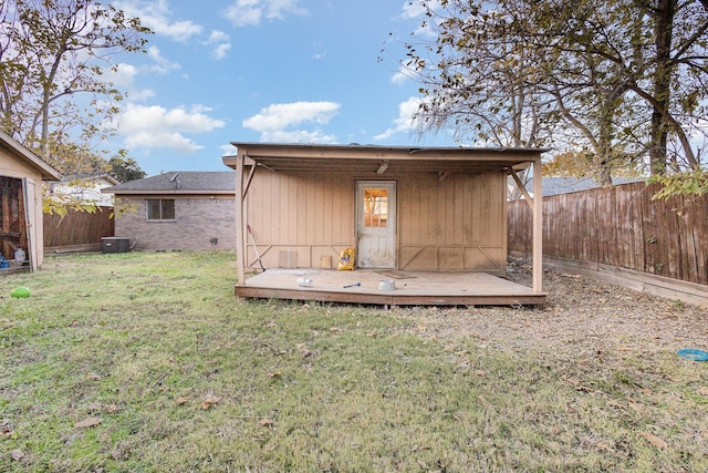 rear view of house featuring central air condition unit and a yard