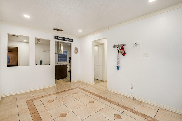 tiled spare room featuring a textured ceiling