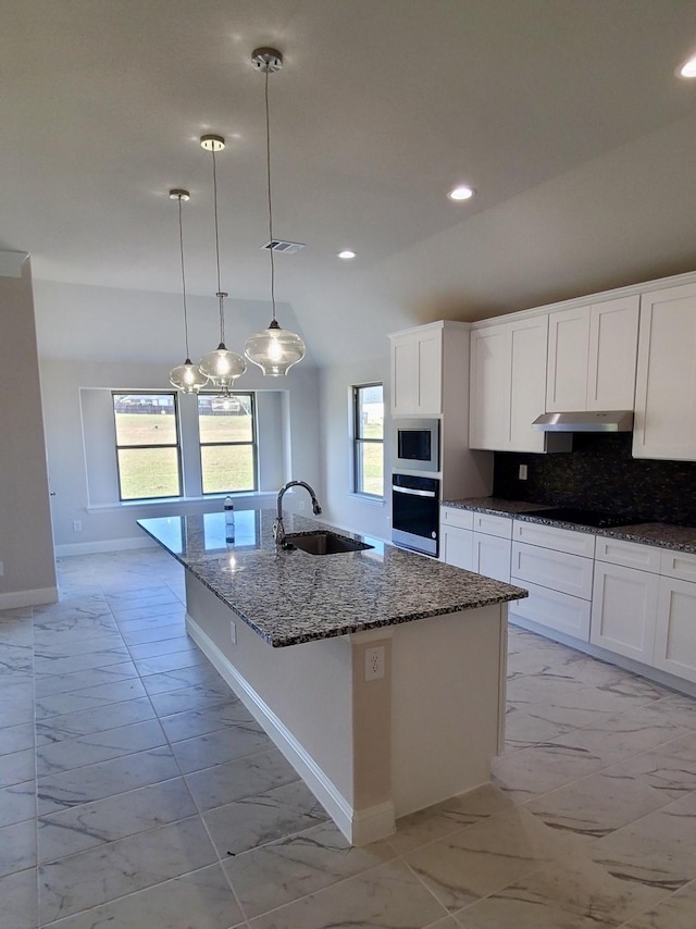 kitchen featuring sink, hanging light fixtures, plenty of natural light, a center island with sink, and appliances with stainless steel finishes