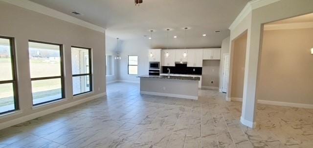 kitchen featuring a center island with sink, stainless steel appliances, ornamental molding, white cabinets, and pendant lighting